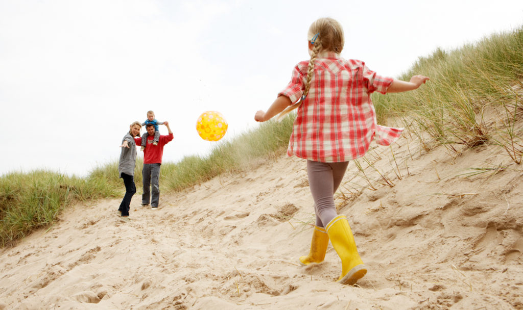 family playing on beach