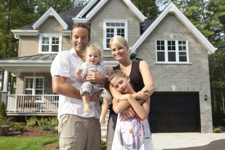 happy family in front of house